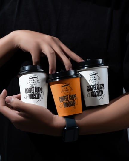 Branded coffee cups held in one hand